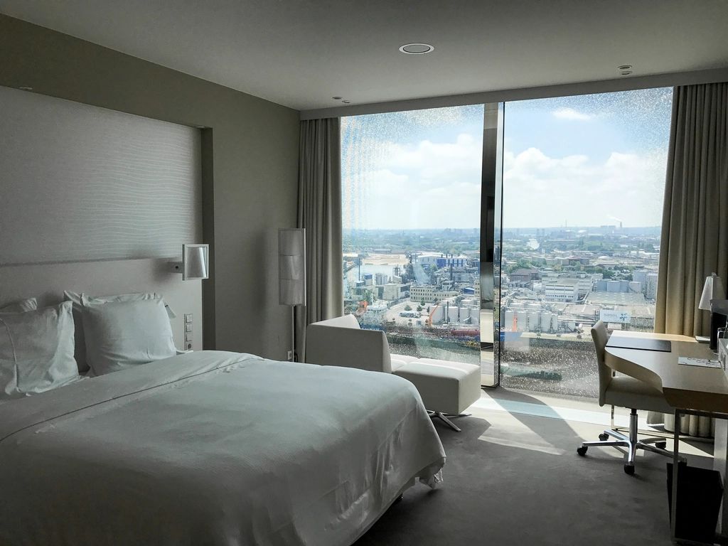 A guest room with a large bed and soft lighting